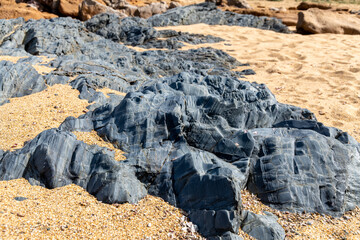 Dark Coastal Rock Formations on Portu Maga Beach