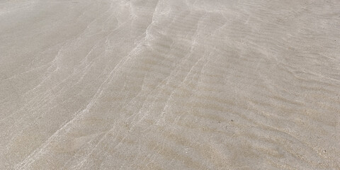 Fototapeta premium Calm water ripples on sand beach. Sea wave motion background wallpaper. Travel holiday summer
