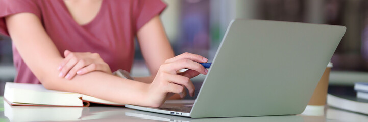 Asian Woman Learning Online with Laptop and Pen on Desk Education Study Resource