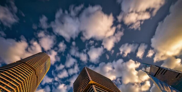 Time-lapse video of modern skyscrapers with moving clouds in the sky