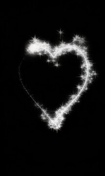 Animated sparkling heart outline in glowing white on black, vertical video format