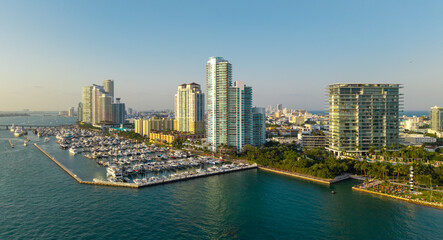 Obraz premium Aerial view of Miami beach with luxury yachts and tropical skyline. Coastline Miami waterfront. Sailboats and yachts in a calm marina and turquoise ocean. Luxury cruise ship.