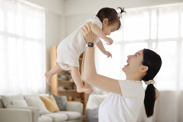 Joyful Mother and Baby Bonding Moment in Bright Living Room with Natural Light and Cozy Decor