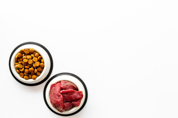 Various pet food in feeding bowls. Natural and dry food for choice. Top view