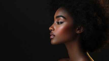 Fototapeta premium Profile portrait of a woman with natural hair against dark background