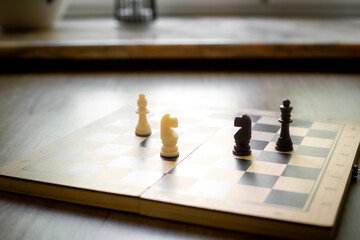 White chess knight piece and other pieces on chessboard during the game