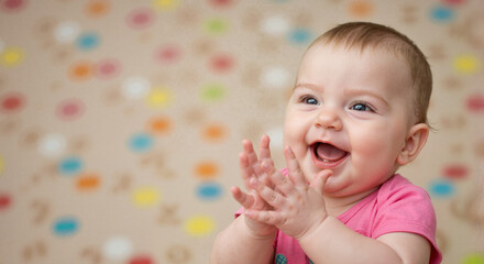 Baby clapping during music, smiling joyfully, on colorful background  