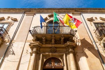 Municipal building facade with flags in Scicli