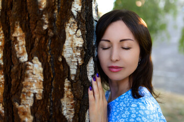 Peaceful Woman Connecting with Nature Leaning on Tree Trunk