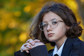 thoughtful teenage girl with round glasses and calm expression