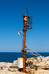 Rusty Signal Mast on Rocky Coast near Syracuse