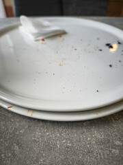Empty plates with remnants of food and a napkin on a table showcasing the aftermath of a meal dining experience and food enjoyment concept
