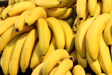 Ripe bananas piled in a pile. Yellow bananas on sale in a supermarket. Food. Grocery background. Bunch of ripe bananas on a street market