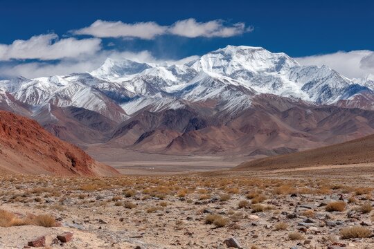 Majestic mountain range with snow-capped peak. Vast valley stretches beneath - Powered by Adobe