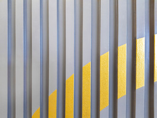 Wallpaper with wooden slats painted in gray and gold, alternating, looks modern and dimensional.