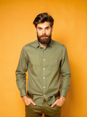 Obraz premium Stylish Bearded Man in Olive Green Shirt Poses Against Yellow Background Studio Portrait
