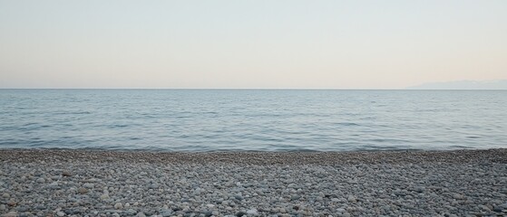 Calm sea meeting pebble beach at sunset, peaceful background for travel or relaxation