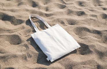 White cotton or mesh bag on beach sand background