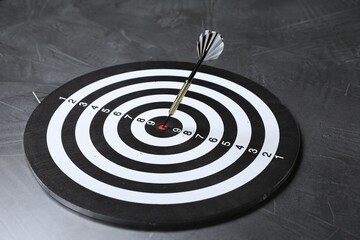 Targeting. Dart board with arrow on gray textured background