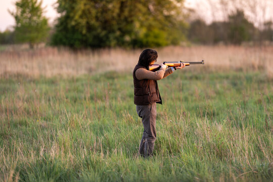 Myśliwy celujący z broni w miękkim świetle wieczora

