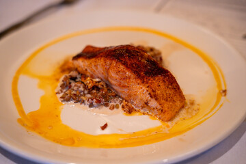 Seared fish fillet served over wild rice at formal dinner