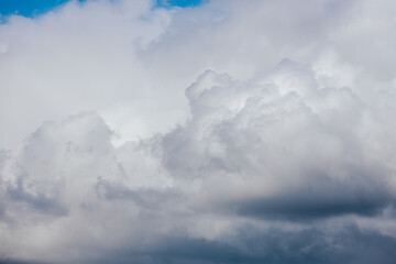 Dark, dense storm clouds gather across the sky, with heavy rain visible in the distance and a few...