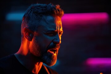 Close-up of a man's face illuminated by orange and pink neon light, shouting with blurred dark background