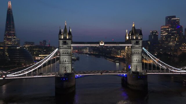 Areal drone breathtaking beauty of London iconic skyline by enjoying a captivating and stunning nighttime aerial view that showcases Tower Bridge along with the shimmering River Thames, England, UK