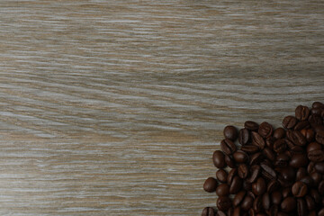 Hot coffee in a white coffee cup and many coffee beans scattered around 