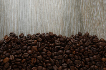 Hot coffee in a white coffee cup and many coffee beans scattered around 