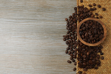 Hot coffee in a white coffee cup and many coffee beans scattered around 