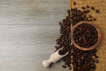 Hot coffee in a white coffee cup and many coffee beans scattered around 