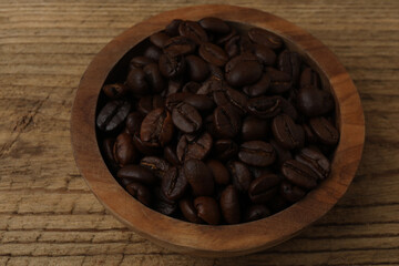Hot coffee in a white coffee cup and many coffee beans scattered around 