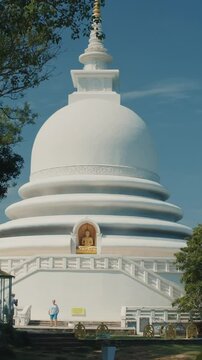 Japanese Peace Temple In Rumassala, Galle, Sri Lanka. Famous landmark and cultural sacred place. The golden statue of Lord Buddha in Parinirvana, Japanese Peace Pagoda.