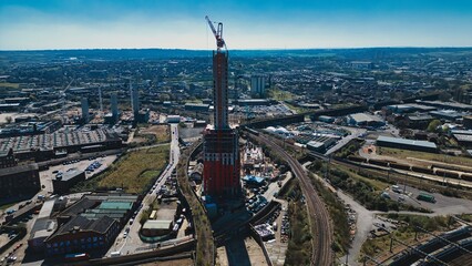Construction Site with Skyscraper and Railway Tracks, Aerial View in Leeds, UK.