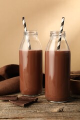 Tasty chocolate milk with pieces on wooden table