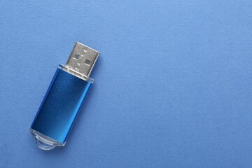 One flash drive on blue background, top view. Space for text