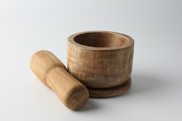 Wooden mortar with pestle on white background, closeup