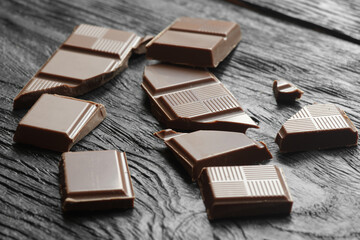 Broken dark chocolate on a wooden table