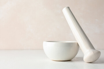 Ceramic mortar and pestle on white table, closeup. Space for text