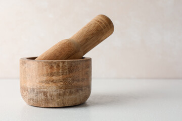 Wooden mortar and pestle on white table, closeup. Space for text