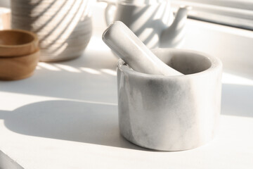 Marble mortar and pestle on windowsill indoors, closeup. Space for text