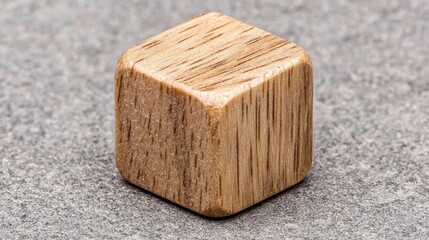 A wooden cube with a light brown color and visible grain.