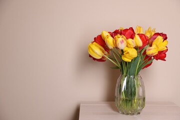 Fototapeta premium Bouquet of beautiful tulips on table against beige background. Space for text