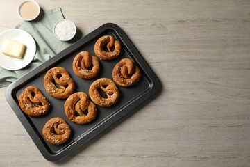 Tasty pretzels and ingredients on wooden table, flat lay. Space for text