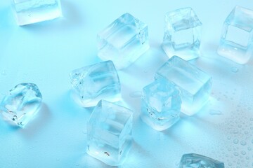 Cubes of clear ice on light blue background, closeup