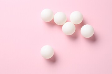 Many ping pong balls on pink background, flat lay