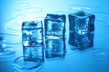 Cubes of clear ice on light blue background