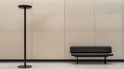 A modern black bench and floor lamp against a beige wall.