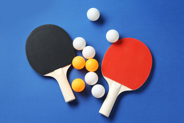 Ping pong rackets and balls on blue background, flat lay